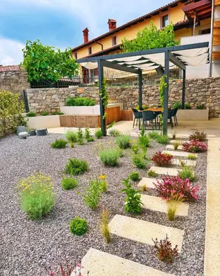 a garden with a patio with a table and chairs at Casa Matko in Kostanjevica na Krasu