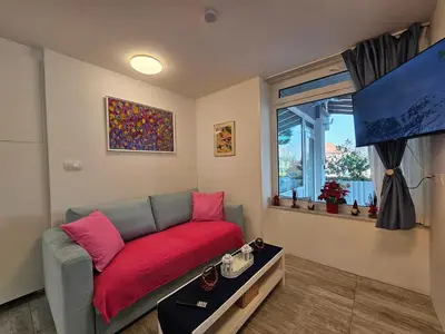 a living room with a couch with a red blanket at Ljubljana Park Apartments Bolero in Ljubljana