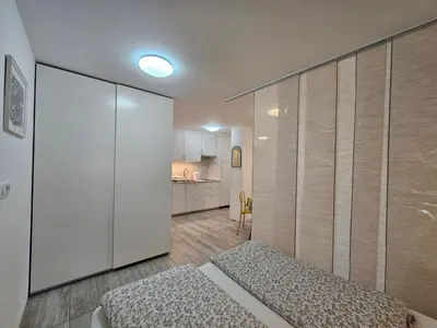a small room with a bed and a kitchen at Ljubljana Park Apartments Bolero in Ljubljana
