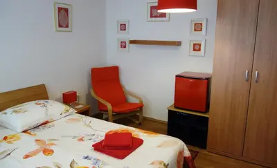 a bedroom with a bed and a chair and a tv at Sobe Vera in Bovec