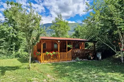 a cabin in the woods with a porch at Mobilna hiška Lebanč in Breginj