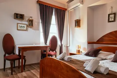 a bedroom with two beds and a desk and a table at Rooms & Restaurant Ostarija in Dolenjske Toplice