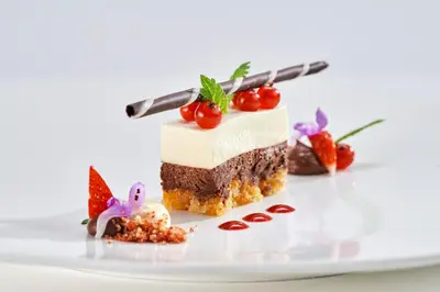 a piece of cake with cherries on a plate at Rooms & Restaurant Ostarija in Dolenjske Toplice