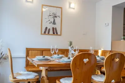 a dining room with a wooden table and chairs at Apartmaji Ježek Kope in Šmartno pri Slovenj Gradcu