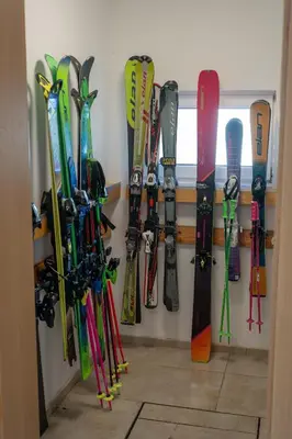 a bunch of skis and snowboards hanging on a wall at Apartmaji Ježek Kope in Šmartno pri Slovenj Gradcu