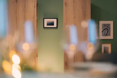 a room with pictures on the wall and a mirror at Peak Haven apartments, Pohorje in Pohorje