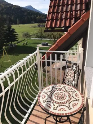a balcony with a table and a white fence at Apartmaji Misotič in Gozd Martuljek