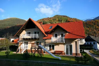 a house with a red roof with a slide at Apartmaji Misotič in Gozd Martuljek
