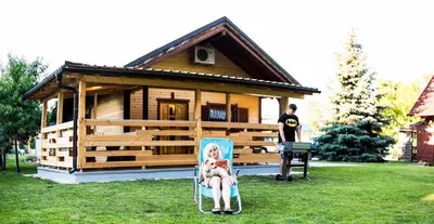 a woman sitting in a chair in front of a cabin at Apartments Brunarica in Moravske Toplice