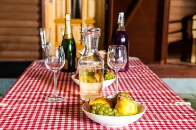 a table with wine glasses and a bowl of fruit at Apartments Brunarica in Moravske Toplice