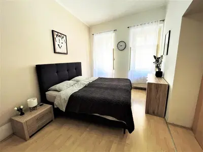 a bedroom with a large bed and a window at Viktorija City Center Apartment in Ljubljana