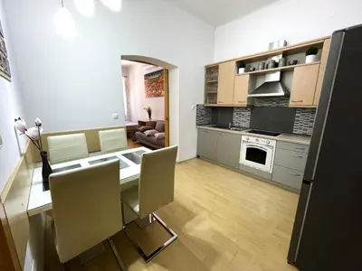 a kitchen and living room with a table and chairs at Viktorija City Center Apartment in Ljubljana