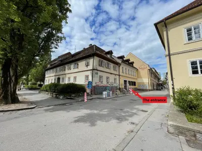 a building on a street with a red arrow at Viktorija City Center Apartment in Ljubljana