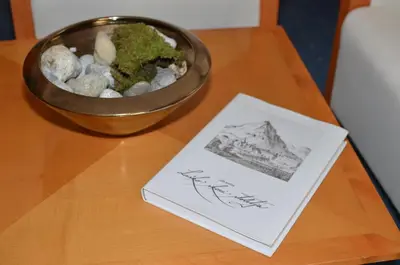 a bowl of rocks and a book on a table at Rooms Savinja in Laško