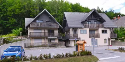 a house with a car parked in front of it at Apartment Bohinjko in Bohinj