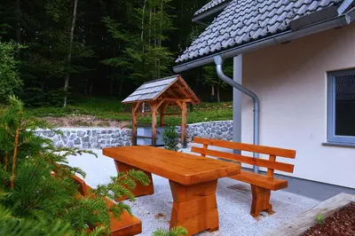 a wooden bench sitting in front of a gazebo at Apartment Bohinjko in Bohinj