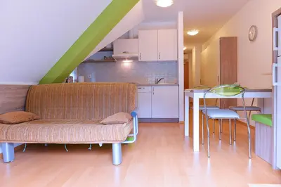 a living room with a couch and a kitchen at Apartment Bohinjko in Bohinj