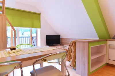 a dining room with green walls and a table and chairs at Apartment Bohinjko in Bohinj