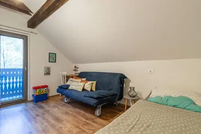 a bedroom with a blue chair and a window at Alpine House Naturalina - Happy Rentals in Slappe dʼIdria