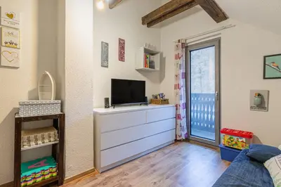a bedroom with a dresser with a tv on it at Alpine House Naturalina - Happy Rentals in Slappe dʼIdria