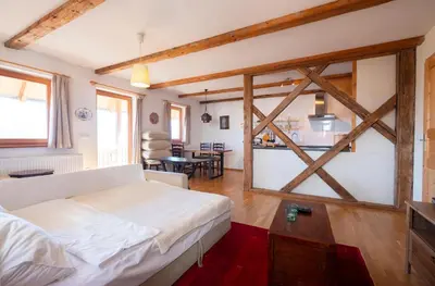 a bedroom with a white bed and a kitchen at Holiday Home Katričnek in Bohinjska Bela