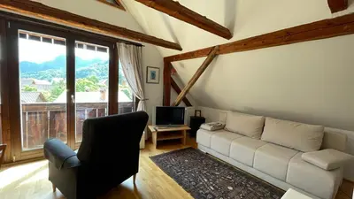 a living room with a couch and a television at Holiday Home Katričnek in Bohinjska Bela