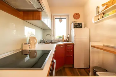 a kitchen with red cabinets and a white refrigerator at Holiday Home Razglednik in Logatec