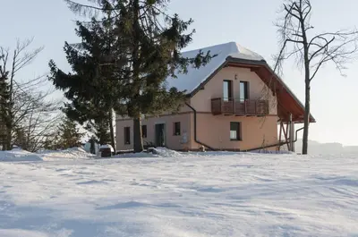 a house in the snow with a snow covered yard at Holiday Home Razglednik in Logatec
