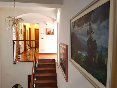 a hallway with a staircase with a large painting on the wall at Rooms Leban in Šempas