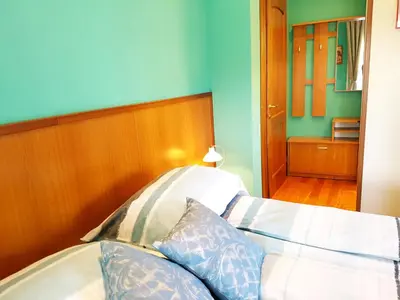 a bedroom with a white bed with blue walls at Rooms Leban in Šempas