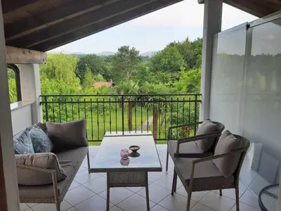 a patio with a table and chairs on a balcony at Rooms Leban in Šempas