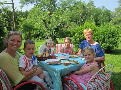 a group of children sitting around a table eating food at Rooms Leban in Šempas