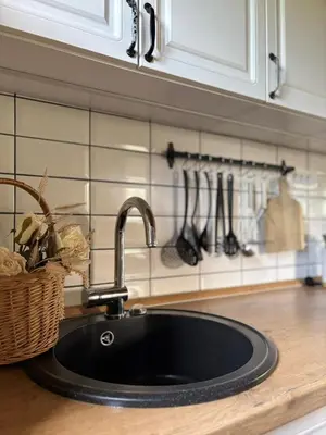 a kitchen sink with a black counter top at Countryside cottage with mountain view in Lukovica pri Domžalah