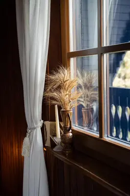 a window with a curtain and potted plants on a ledge at Countryside cottage with mountain view in Lukovica pri Domžalah
