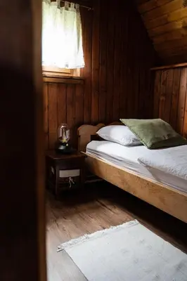 a bed in a wooden room with a window at Countryside cottage with mountain view in Lukovica pri Domžalah