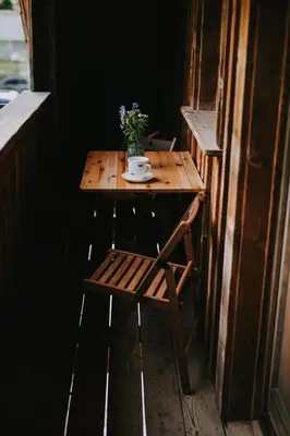 a small wooden table with a cup and flowers on it at Apartments Julijana in Kranjska Gora