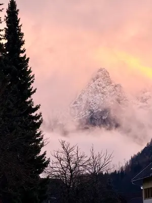 a mountain covered in snow with a rainbow in the sky at Apartments Julijana in Kranjska Gora