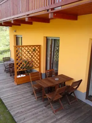a wooden deck with a wooden table and chairs at Apartments Maligoj in Tolmin