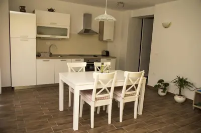 a white kitchen with a white table and chairs at Apartments Maligoj in Tolmin