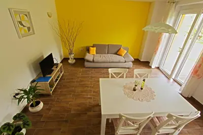 a living room with a white table and a couch at Apartments Maligoj in Tolmin
