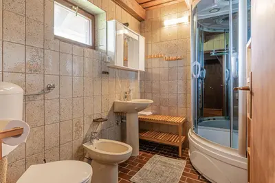 a bathroom with a toilet and a sink and a tub at Podhamer Wellness Vineyard Cottages in Ljutomer