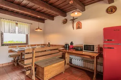 a kitchen with a table and a red refrigerator at Podhamer Wellness Vineyard Cottages in Ljutomer