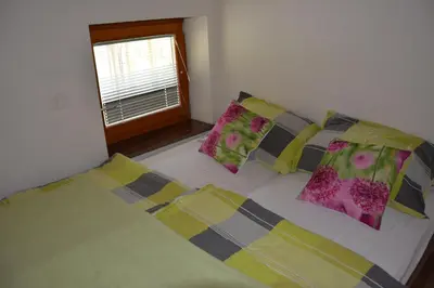a bedroom with a bed with pillows and a window at Apartmaji Kobal in Zoll