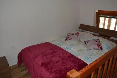a bedroom with a bed with a purple blanket and pillows at Apartmaji Kobal in Zoll