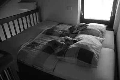a bed with a blanket on it in a bedroom at Apartmaji Kobal in Zoll