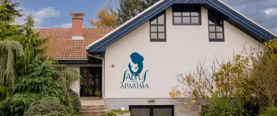 a white house with a sign on the side of it at Luxury Wellnes Glamping Cottage - Salvus in Lendava