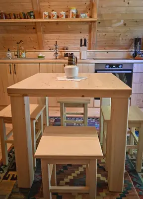 a kitchen with a wooden table and some chairs at Luxury Wellnes Glamping Cottage - Salvus in Lendava