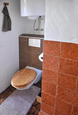 a bathroom with a toilet with a wooden toilet seat at Luxury Wellnes Glamping Cottage - Salvus in Lendava