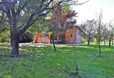 a house in a field with trees and grass at Luxury Wellnes Glamping Cottage - Salvus in Lendava