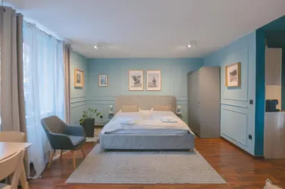 a bedroom with a bed and a blue wall at BRIDGE apartments in Ljubljana